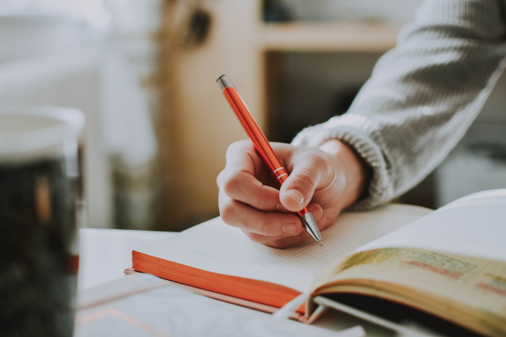 Persona escribiendo en un diario — autorregistro psicológico